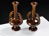 two brown vases sitting on a white table