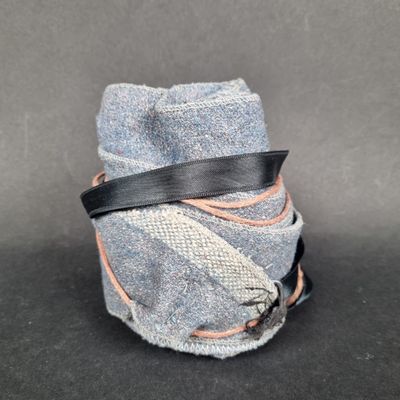 an image of a roll of cloth wrapped in a black ribbon