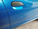 a close up of a blue car door handle with a sticker on it