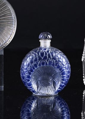 a blue glass bottle sitting on a table next to a mirror