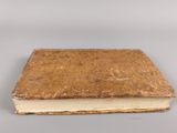 an old book sitting on top of a table with a white background