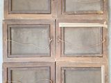 six wooden windows with glass panels on them on a wall