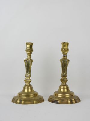 pair of antique brass candlesticks on a white background