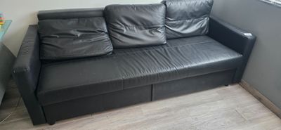 un canapé en cuir noir dans un coin de la pièce