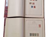 two pages of a book with stamps are open on a white surface