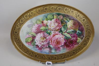 a gold plate with a painting of roses on it