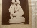 an old photo of a statue of a man and a woman kissing