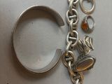 a silver bracelet with a ring and a bracelet with charms on it