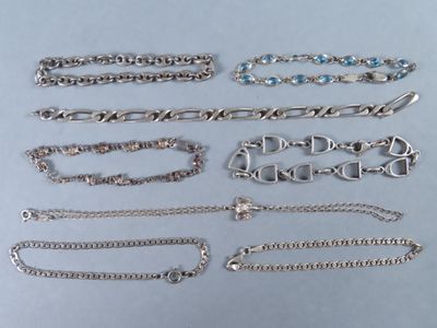 plusieurs types de bracelets et de chaînes en argent posés sur une table