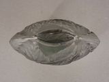 a glass ashtray on a table with a white background