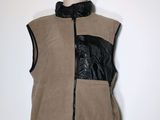 une photo d'un mannequin portant un gilet beige orné de bordures en cuir noir