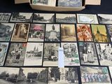several old black and white photos are on a table with a box full of them