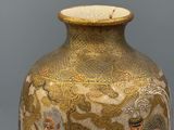 a vase with a painting on it sitting on a table