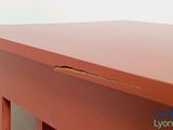 a close up of a red table with a hole in it