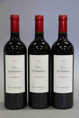 trois bouteilles de vin rouge posées côte à côte sur une table