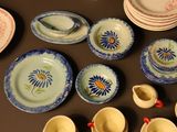 many plates, cups, and spoons on the table