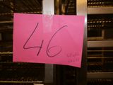 une pancarte rose sur laquelle est inscrit « 46 », placée devant un présentoir de produits alimentaires