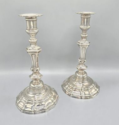 pair of silver candlesticks on a white background