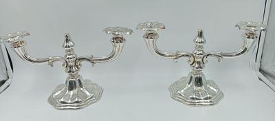 paire de bougeoirs plaqués argent, ornés de fleurs à chaque extrémité