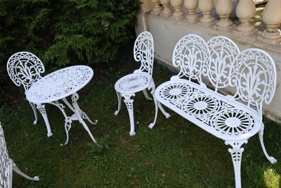 trois chaises blanches et une table dans le jardin