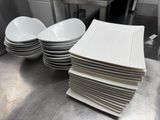 several white plates stacked on top of each other in a kitchen