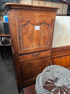 une grande armoire en bois surmontée d'une porte vitrée