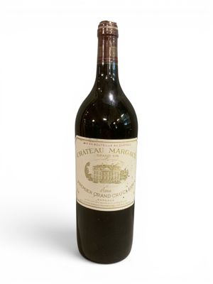 une vieille bouteille de vin posée sur une table blanche