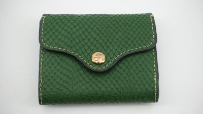 un petit portefeuille vert orné d'un bouton doré sur le devant