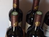several bottles of wine are lined up on a wooden table