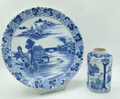 une assiette bleue et blanche et un vase posés sur une table
