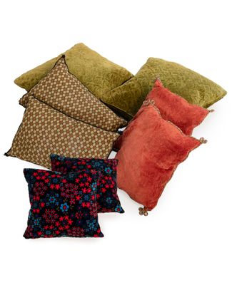 several different colored pillows on a white surface with a white background