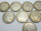 a close up of a bunch of silver coins on a table