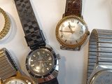 many different types of watches displayed on a table