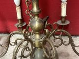 a brass chandelier with three candles on it