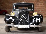 a black car parked in front of a brick wall