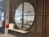 un grand miroir rond accroché au mur au-dessus d'un comptoir
