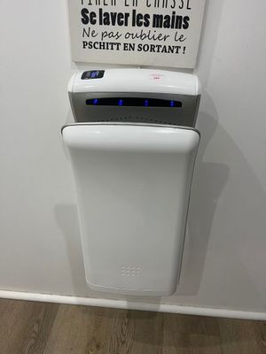 un distributeur de papier essuie-tout fixé au mur, à côté d'un panneau