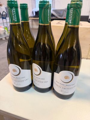 trois bouteilles de vin sont posées sur une table dans une pièce