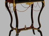 a black table with a red top and gold trimmings