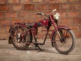 a red motorcycle that is parked in front of a brick wall