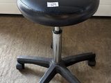 an image of a black stool on wheels in a room