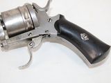 a silver revolver with a black handle on a white surface