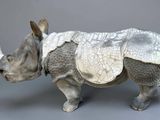 a sculpture of a rhino with a saddle on it ' s back