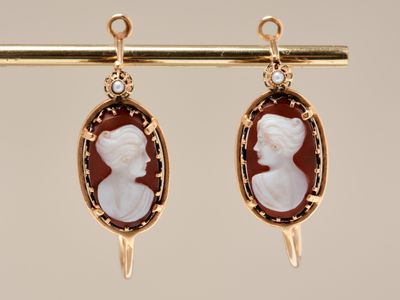 an image of a pair of earrings with a woman ' s profile on them