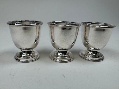 three silver cups sitting on top of each other on a table