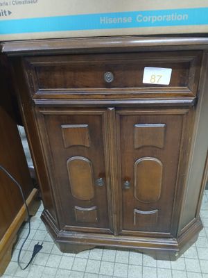 a wooden cabinet with a sign on it in a store