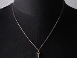 a black mannequin torso with a silver necklace and a blue stone pendant