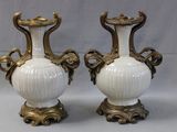 two white vases with gold handles on a white background