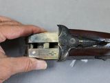 a hand that is holding a gun in it ' s right hand