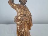bronze statue of a man holding a staff on a white surface